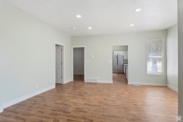 interior space with wood finished floors, baseboards, visible vents, and recessed lighting