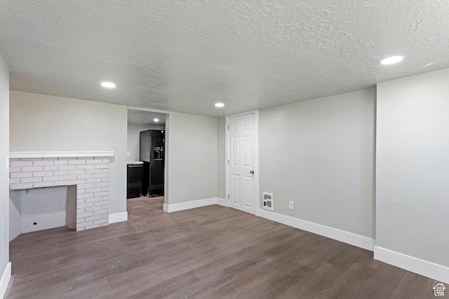 unfurnished living room with a textured ceiling, visible vents, dark wood-style flooring, baseboards, and recessed lighting