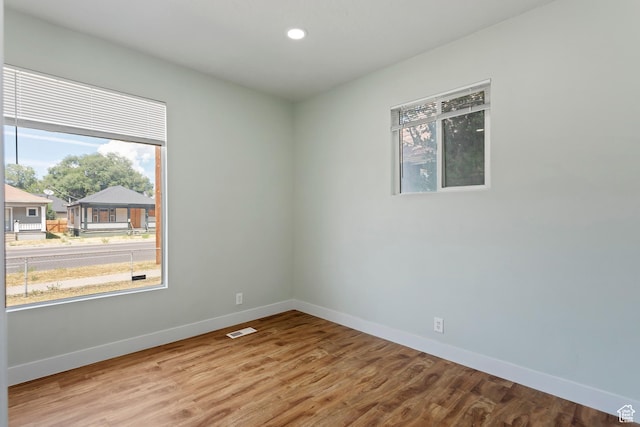 unfurnished room with baseboards, visible vents, and plenty of natural light