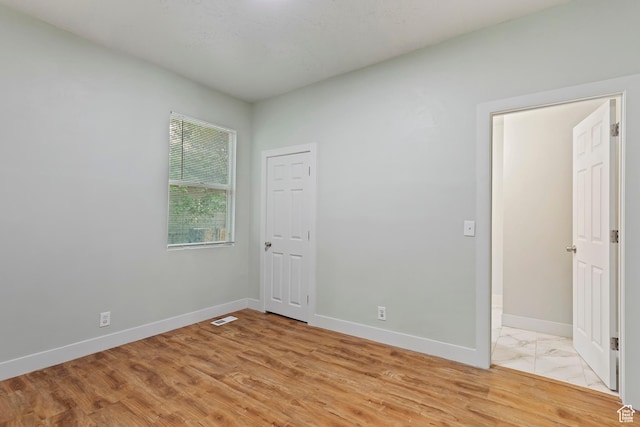 spare room with baseboards and visible vents
