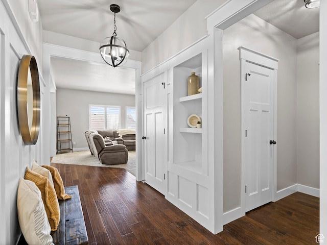 1827 W Burke Ln, Farmington, UT 84025 - hallway featuring dark wood-style flooring, baseboards, an inviting chandelier, and built in shelves