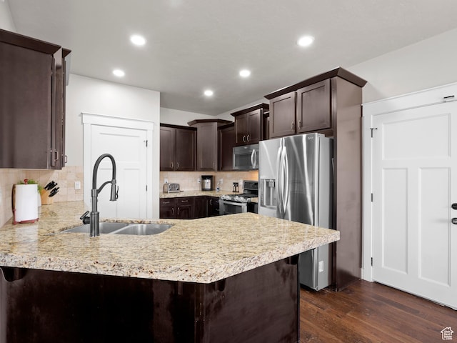1827 W Burke Ln, Farmington, UT 84025 - kitchen featuring a sink, dark brown cabinetry, a peninsula, stainless steel appliances, and tasteful backsplash