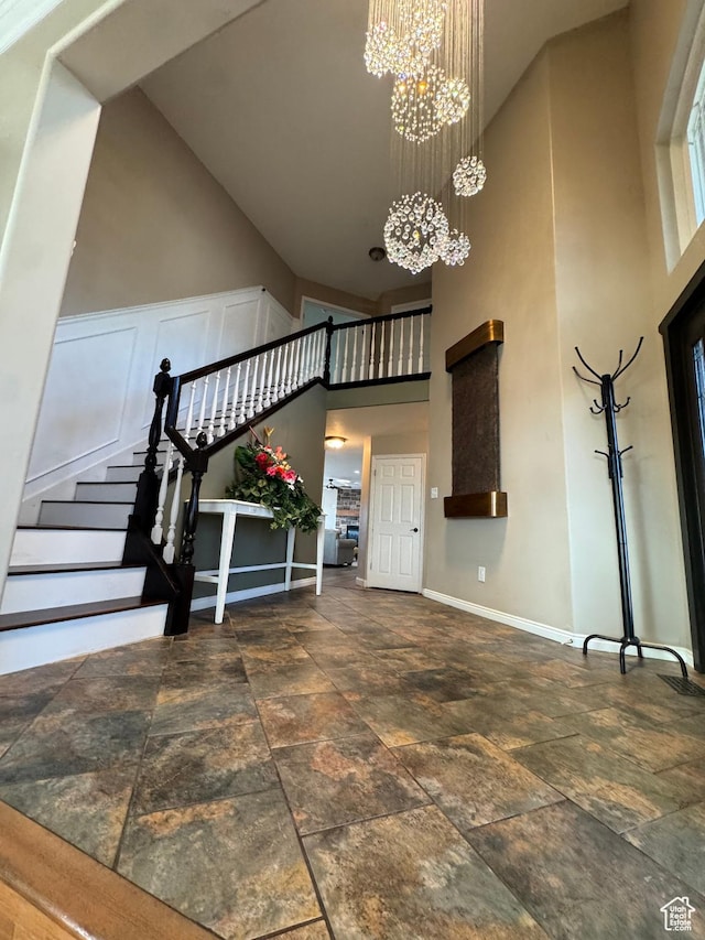 2247 Country Oaks Dr, Layton, UT 84040 - entryway with a chandelier, baseboards, stone finish floor, and high vaulted ceiling