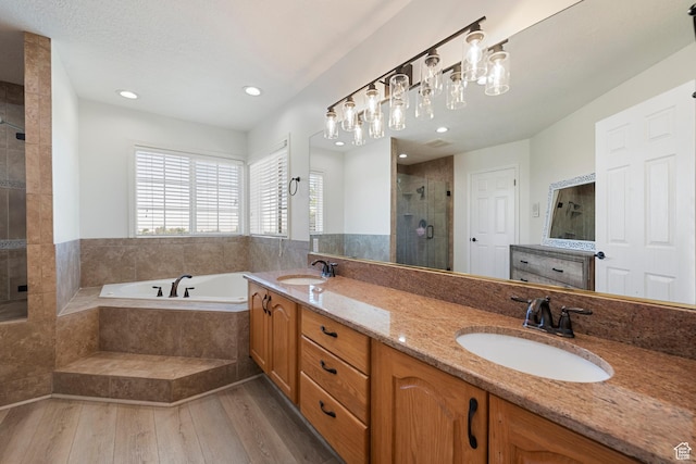 2247 Country Oaks Dr, Layton, UT 84040 - bathroom with a stall shower, a bath, double vanity, wood finished floors, and recessed lighting