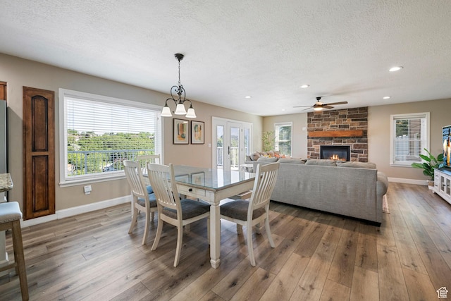 2247 Country Oaks Dr, Layton, UT 84040 - dining room with a fireplace, a textured ceiling, wood-type flooring, ceiling fan, and plenty of natural light