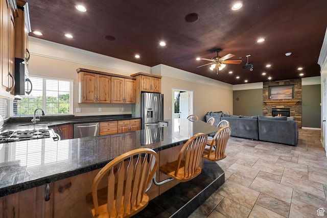2247 Country Oaks Dr, Layton, UT 84040 - kitchen featuring stainless steel appliances, crown molding, a breakfast bar area, ceiling fan, and a peninsula
