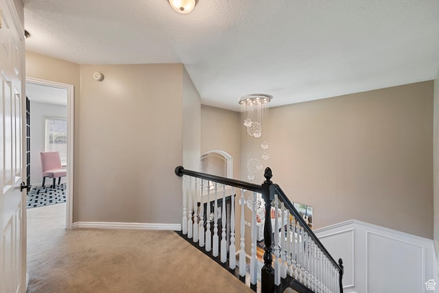 2247 Country Oaks Dr, Layton, UT 84040 - corridor featuring an upstairs landing, carpet flooring, a textured ceiling, and a chandelier