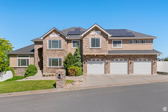 2247 Country Oaks Dr, Layton, UT 84040 - view of front of house with a garage, stone siding, driveway, and solar panels