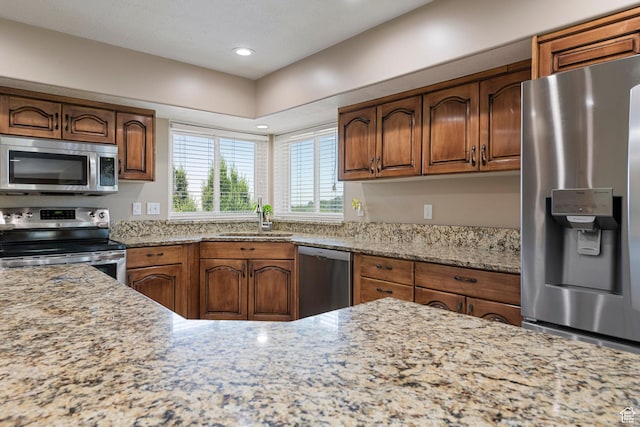 2247 Country Oaks Dr, Layton, UT 84040 - kitchen with stainless steel appliances, light stone countertops, brown cabinets, and recessed lighting
