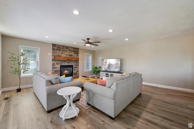 2247 Country Oaks Dr, Layton, UT 84040 - living room featuring ceiling fan, a textured ceiling, light wood-style flooring, a fireplace, and recessed lighting