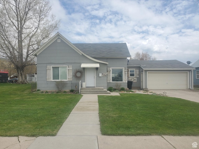 view of front of home with a shingled roof, concrete driveway, an attached garage, and a front yard