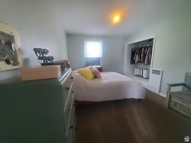 bedroom featuring heating unit and a closet