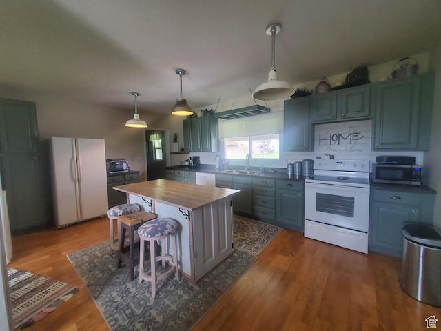 kitchen featuring pendant lighting, dark wood-style flooring, white appliances, wooden counters, and a sink