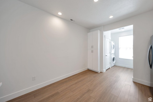 interior space featuring baseboards, recessed lighting, visible vents, and stacked washer and clothes dryer