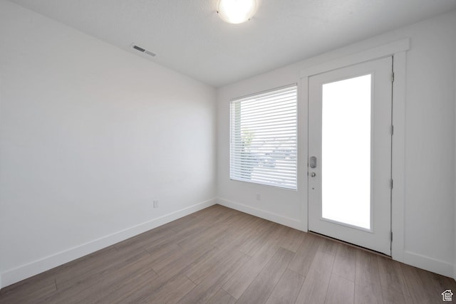 entryway with visible vents, wood finished floors, and baseboards
