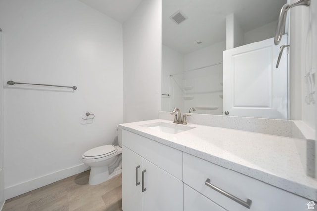 bathroom featuring walk in shower, toilet, wood finished floors, vanity, and visible vents