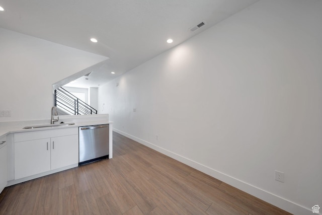 kitchen featuring recessed lighting, stainless steel dishwasher, visible vents, a sink, and light wood-style floors