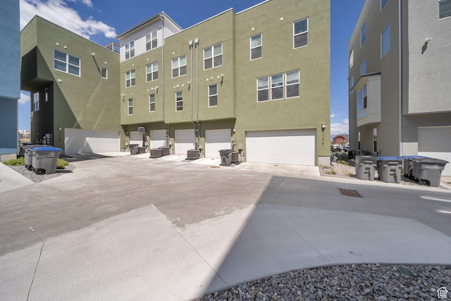exterior space with central AC unit and an attached garage