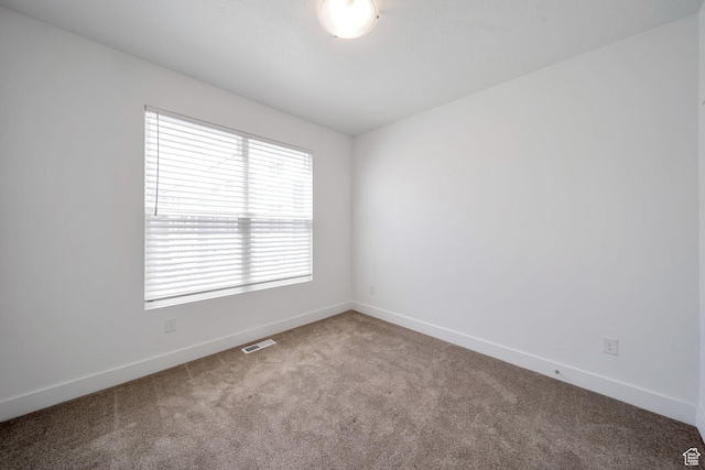 empty room with visible vents, baseboards, and carpet floors