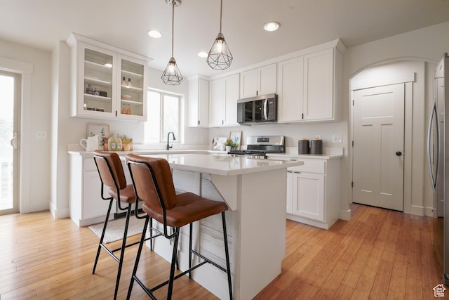235 E Caracara St S, Saratoga Springs, UT 84043 - kitchen with a breakfast bar, stainless steel appliances, white cabinets, and a center island