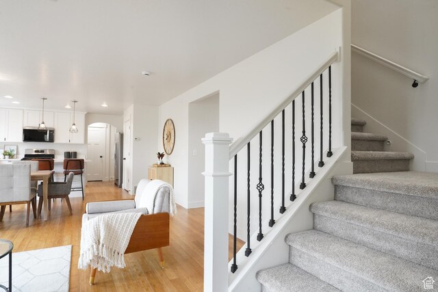 235 E Caracara St S, Saratoga Springs, UT 84043 - staircase with wood finished floors, arched walkways, and recessed lighting