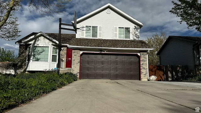 view of front facade with fence, a garage, brick siding, and driveway