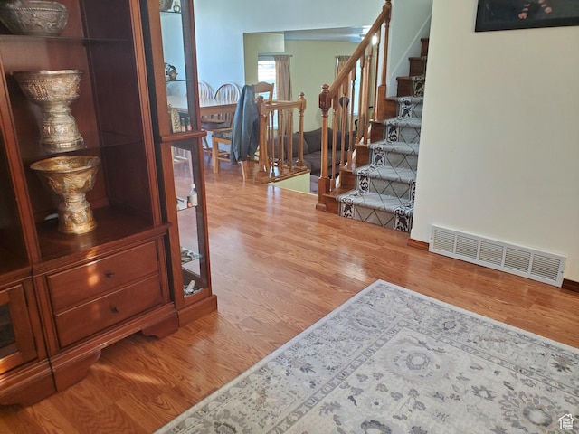 interior space with stairway, visible vents, and wood finished floors