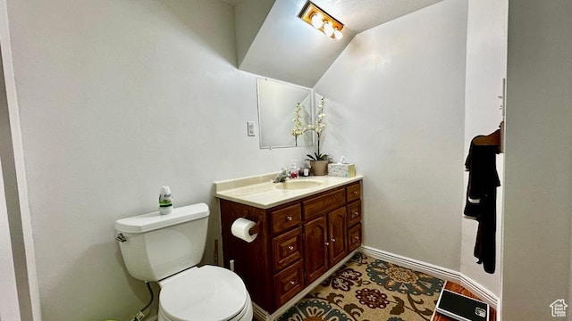 bathroom featuring toilet, baseboards, and vanity