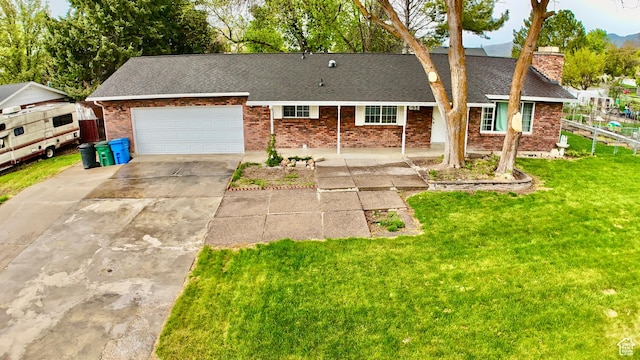651 E 2160 N, North Logan, UT 84341 - single story home featuring driveway, brick siding, a garage, a shingled roof, and a front yard