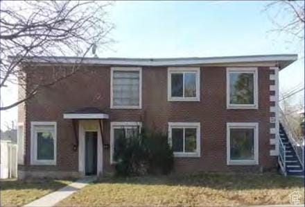 view of front of home featuring a front lawn and stairway