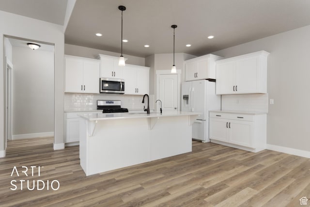 814 E 110 S, Salem, UT 84653 - kitchen featuring stainless steel appliances, white cabinets, light wood-type flooring, light countertops, and decorative backsplash