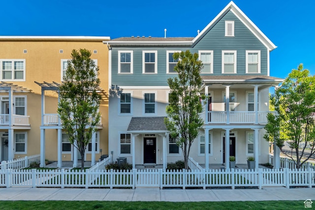 view of front of property with a balcony, a pergola, stucco siding, and a fenced front yard
