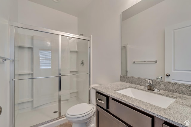 bathroom with vanity, toilet, and a stall shower