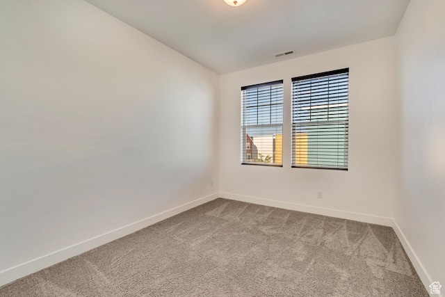 carpeted spare room with baseboards and visible vents