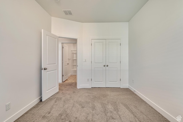 unfurnished bedroom with carpet flooring, baseboards, a closet, and visible vents