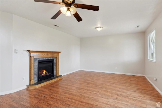 3035 N 2575 W, Farr West, UT 84404 - unfurnished living room with a premium fireplace, a ceiling fan, baseboards, light wood finished floors, and visible vents