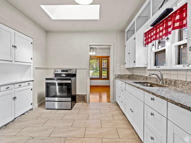 1362 Marilyn Dr, Ogden, UT 84403 - kitchen with stainless steel electric range oven, a sink, a skylight, and white cabinetry