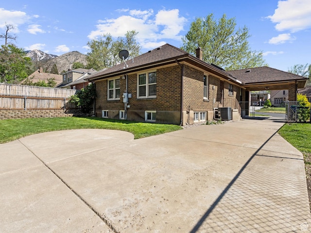 1362 Marilyn Dr, Ogden, UT 84403 - view of side of property with a chimney, central AC, brick siding, concrete driveway, and a mountain view