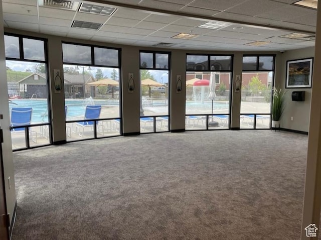 empty room with carpet and a paneled ceiling