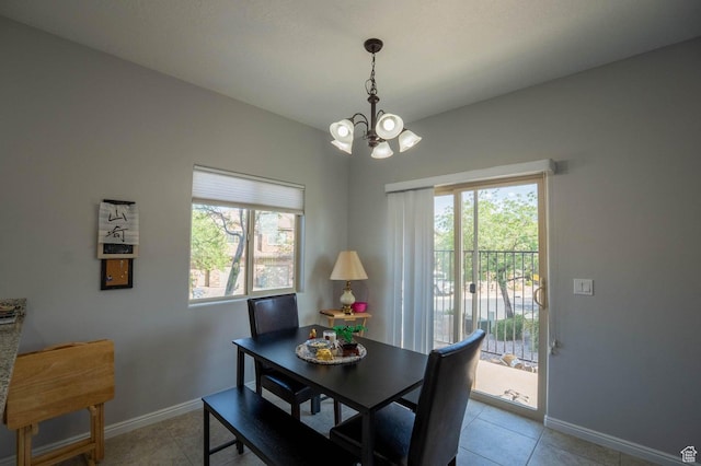 dining area with a notable chandelier, baseboards, and light tile patterned floors
