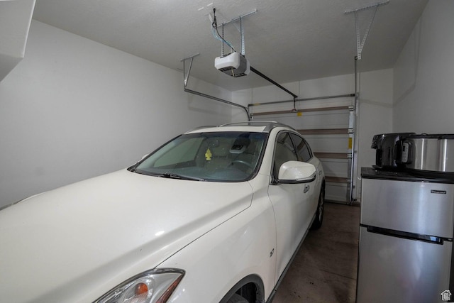 garage featuring freestanding refrigerator and a garage door opener