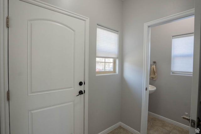 doorway to outside with baseboards and light tile patterned floors