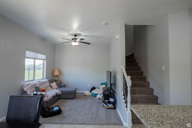 unfurnished living room featuring stairs, carpet, baseboards, and a ceiling fan