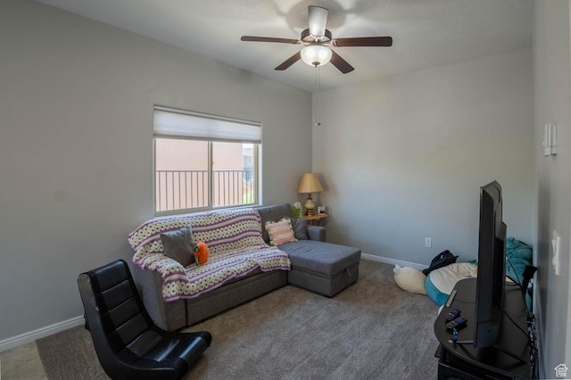 carpeted living area featuring baseboards and a ceiling fan