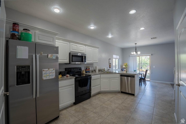 kitchen with visible vents, white cabinetry, a peninsula, a chandelier, and appliances with stainless steel finishes