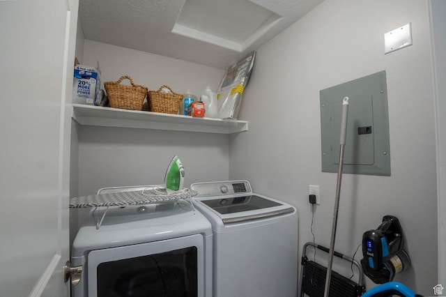 clothes washing area with washing machine and dryer, laundry area, attic access, and electric panel