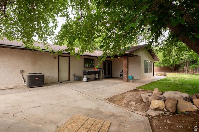 944 Gardenia Cir, St George, UT 84790 - rear view of property featuring a patio, stucco siding, fence, central air condition unit, and a yard
