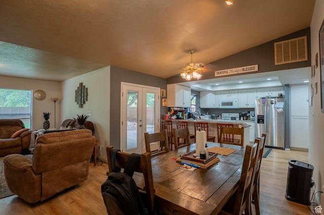 944 Gardenia Cir, St George, UT 84790 - dining space with french doors, a ceiling fan, visible vents, light wood-style floors, and vaulted ceiling