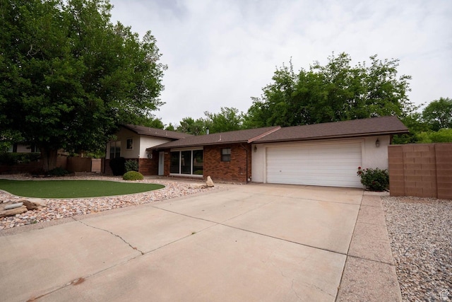 944 Gardenia Cir, St George, UT 84790 - tri-level home featuring driveway, brick siding, a garage, and fence