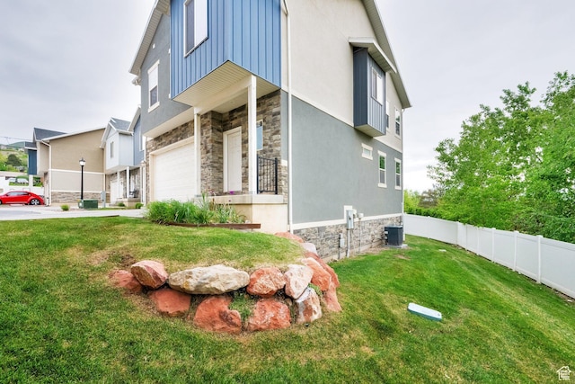 94 S Walker Ln, North Salt Lake, UT 84054 - view of home's exterior with stone siding, an attached garage, concrete driveway, central air condition unit, and stucco siding